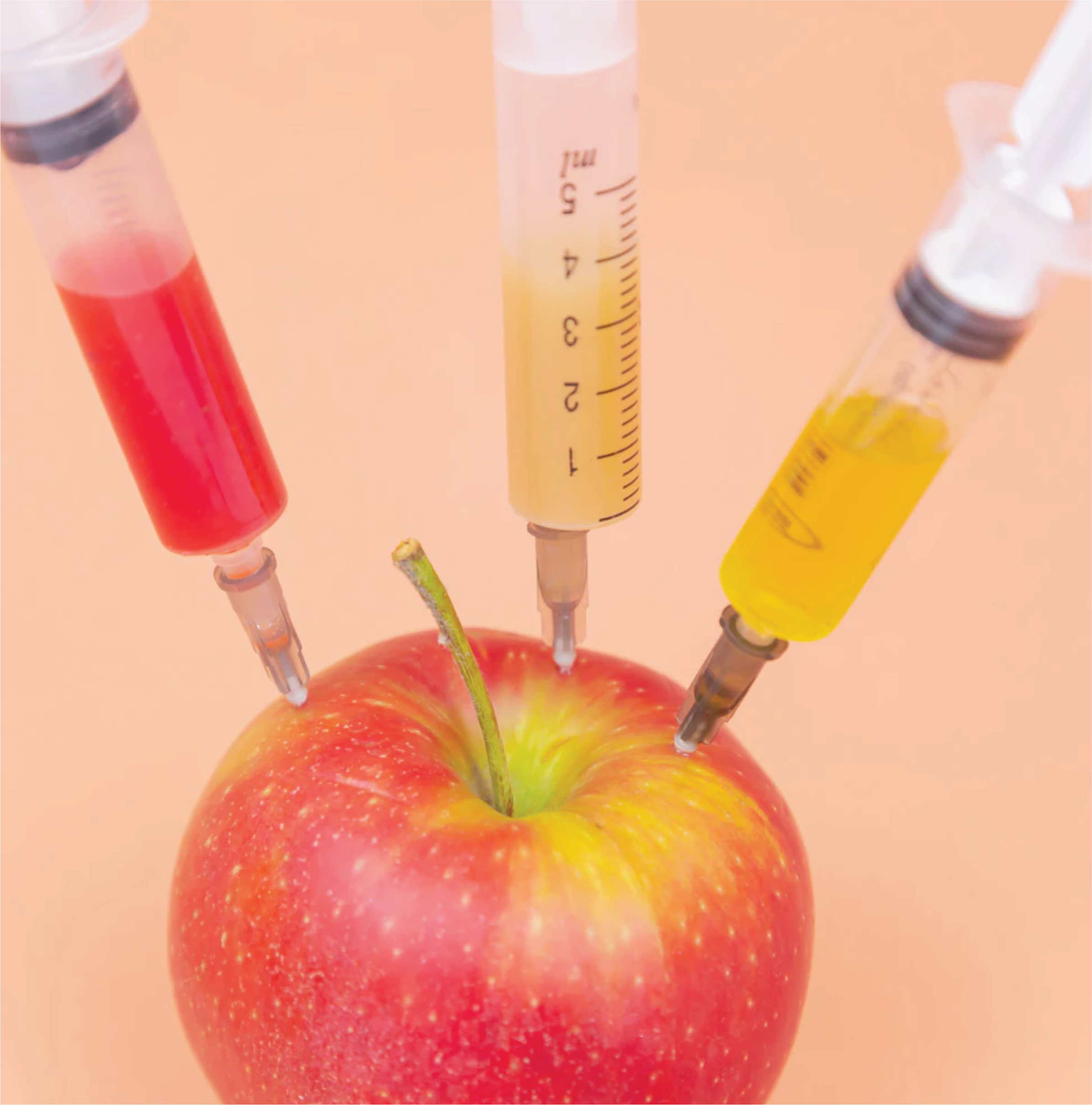 syringes injecting an apple